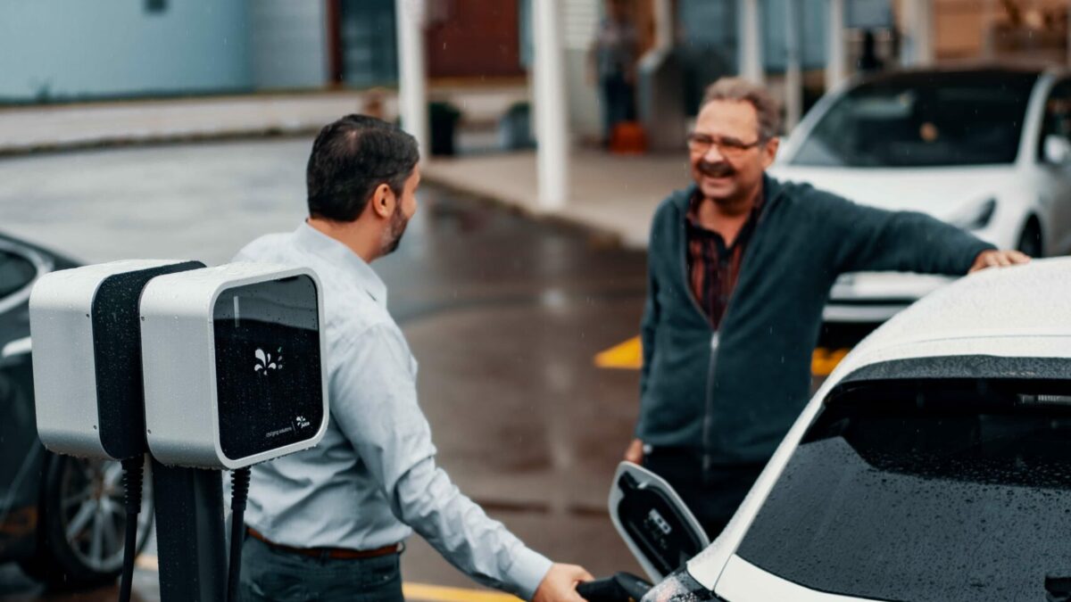 Employés qui rechargent véhicule électrique en entreprise grâce à une borne de recharge