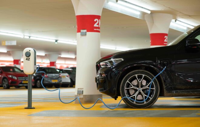 Voiture en train de charger sur une borne électrique dans un parking d'entreprise