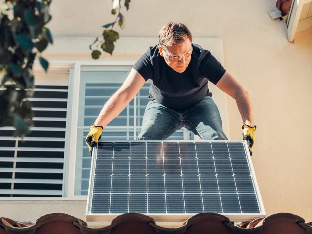Homme qui installe un panneau photovoltaïque
