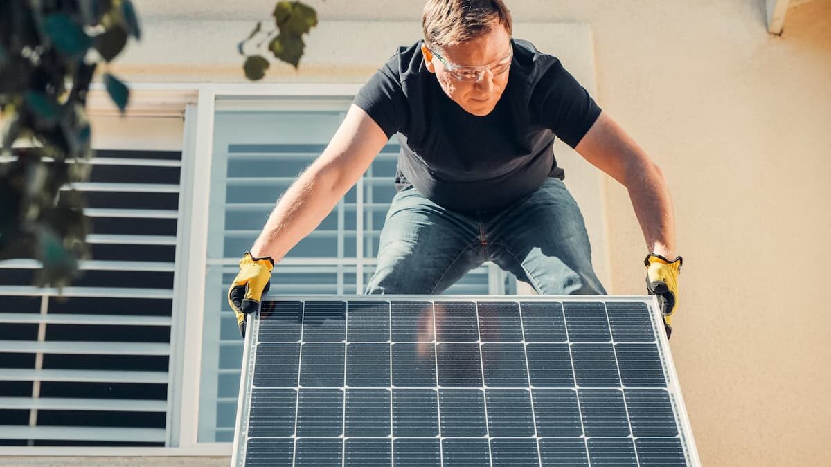 Homme qui installe un panneau photovoltaïque