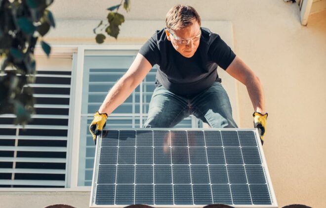 Homme qui installe un panneau photovoltaïque